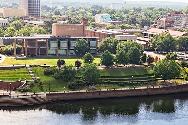 four students sitting on a stone bench