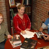 female teacher and two students going over an assignment