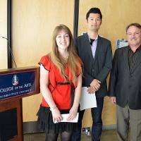 Three individuals smiling next to a "College of the Arts" podium