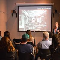 A lecture in an art gallery, a slideshow of a Duchamp painting