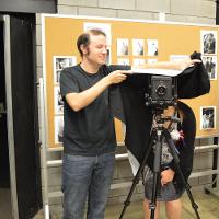 A professor helping a student take a photo  