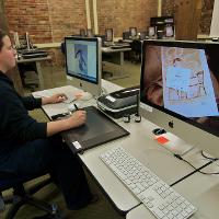 A student working on an art project in a computer lab 
