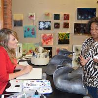 Two ladies chatting in an art studio 