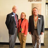 Two men and a woman, dressed nicely, smiling in the Illges art gallery 