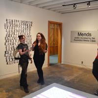 Three people in an art gallery 