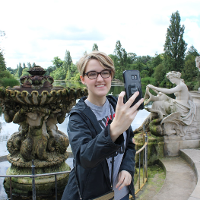 A student taking a selfie next to a statue 