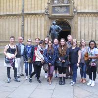 Students posing next to a statue
