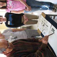 Students watching an older artist paint 