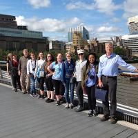Students and faculty smiling on a bridge 