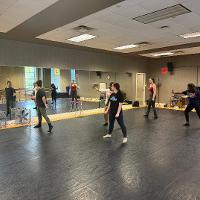 Dancers practicing in mirrored dance studio