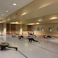 Dance students rehearsing floor work in studio
