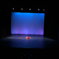 Solo dancer performing on blue-lit stage