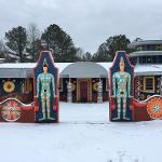 Pasaquan entrance gate with two painted figure totems covered in fresh snow