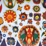 White wall covered in colorful sculpted floral and sun medallion designs