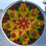 Large circular medallion with star pattern and yin-yang symbol flanked by face sculptures