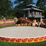 Painted sand circle and pagoda building with decorative walls and totem figures
