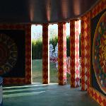 Interior of painted pavilion with colorful diamond-patterned columns and medallion murals