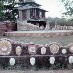 Historic photo of Pasaquan pagoda building with sun and face medallion wall