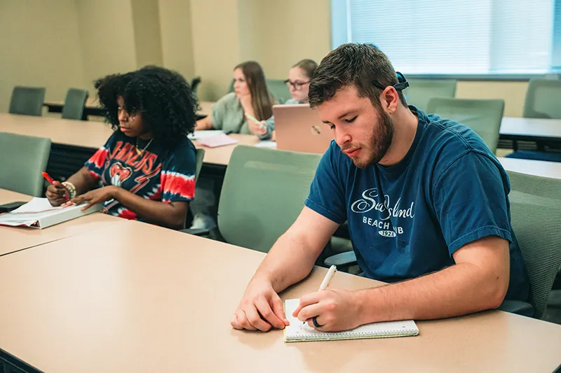 Students taking notes in a college classroom