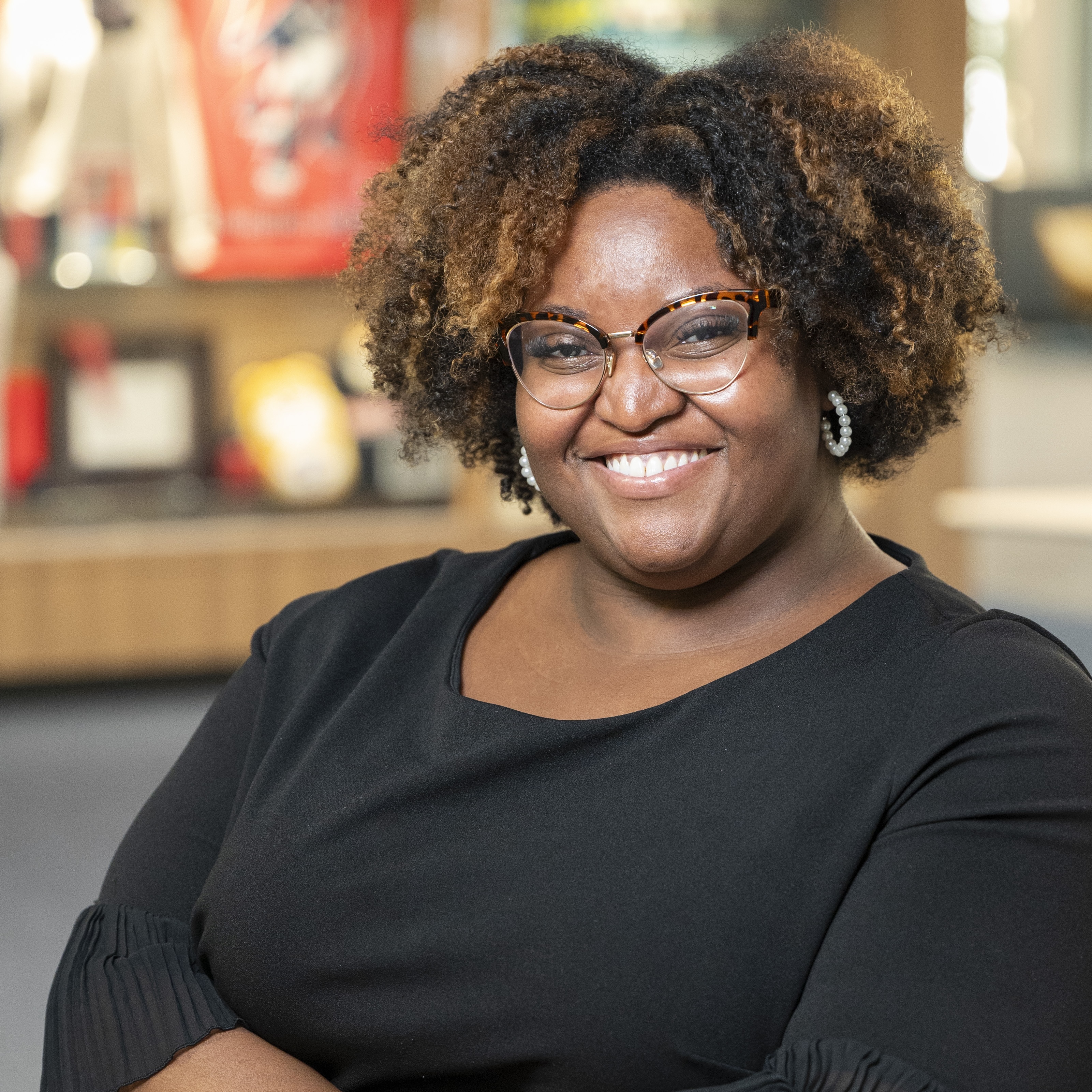 a woman wearing a black dress with glasses