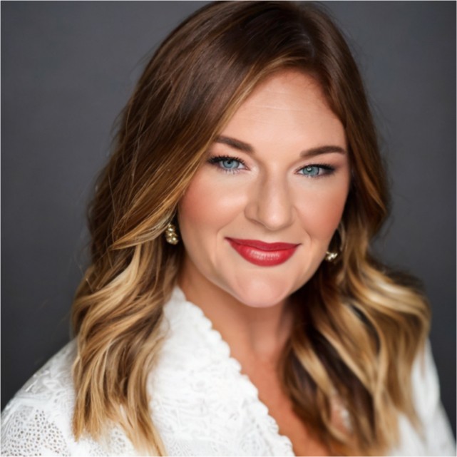 a woman wearing a black suit leaning against a wall with her arms crossed