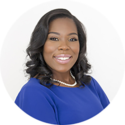 a woman wearing a blue dress witha. pearl necklace