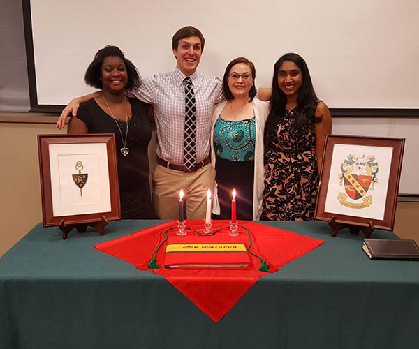 Four students standing behind a table