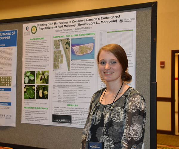 A female student standing in front of a presentation board