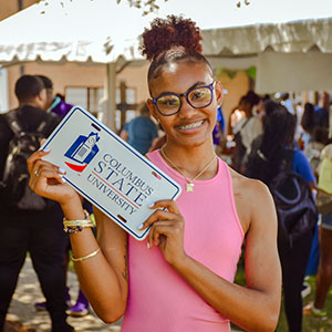 Student holding a Columbus State University sign at convocation