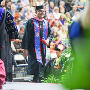 Graduate walking across the commencement stage