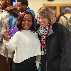 Student taking a selfie with a university staff member