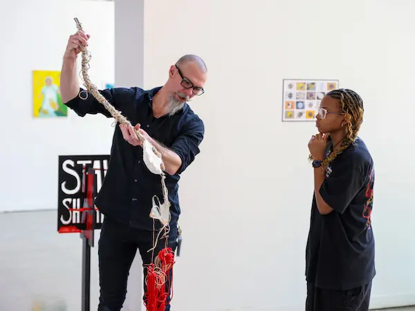 Travis Dodd showing a student some art