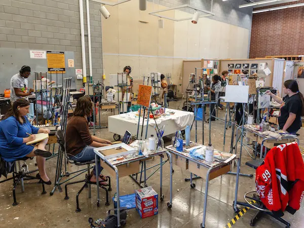 Art classroom with students painting at easels