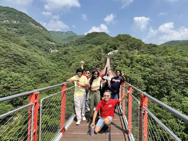 students and faculty on a suspended bridge