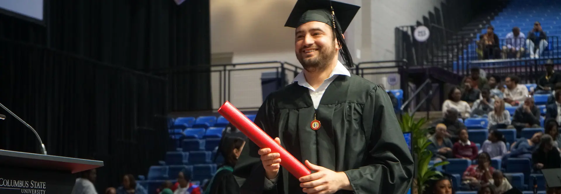 a male receiving his diploma at graduation