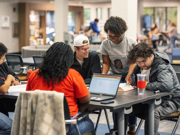 students studying at a table in the library