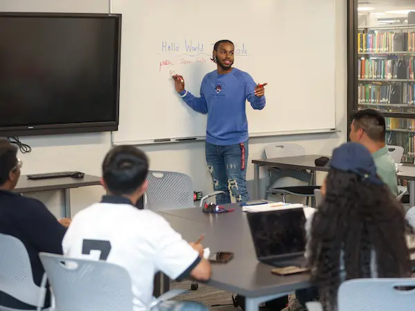 A male teaching at a whiteboard