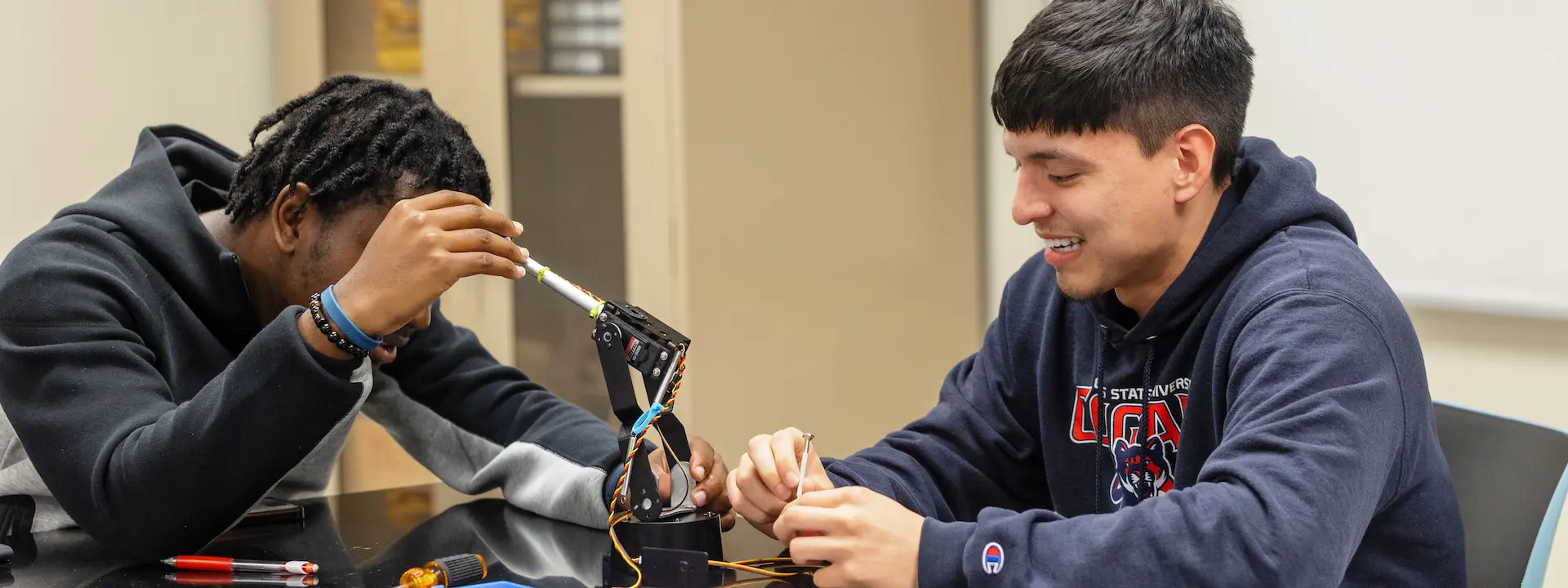 two male students working on a small electrical machine
