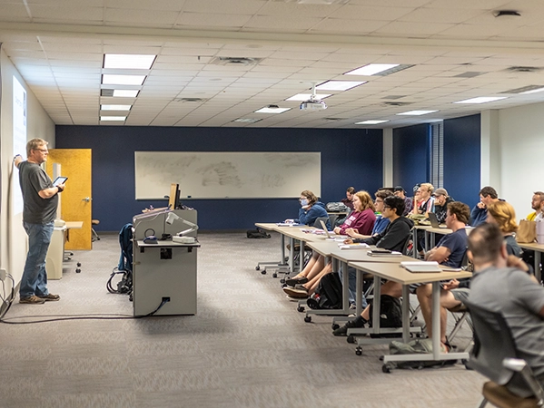 A class in session as a professor gives a lecture to his students.