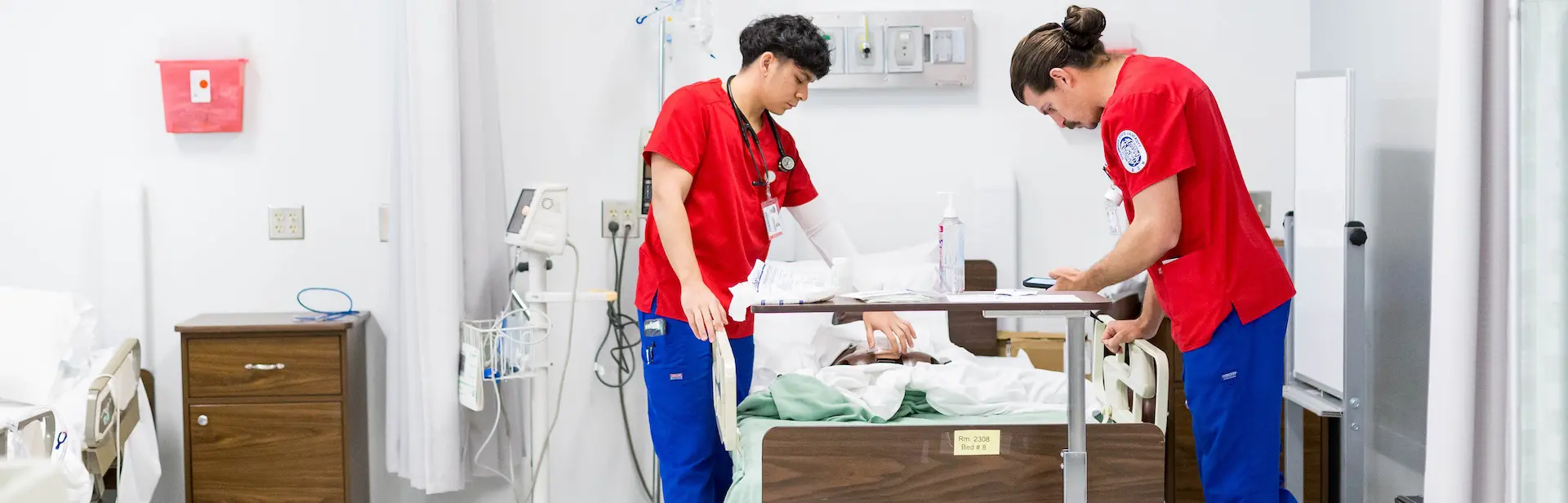 to male nursing students training in a hospital room with a robot patient