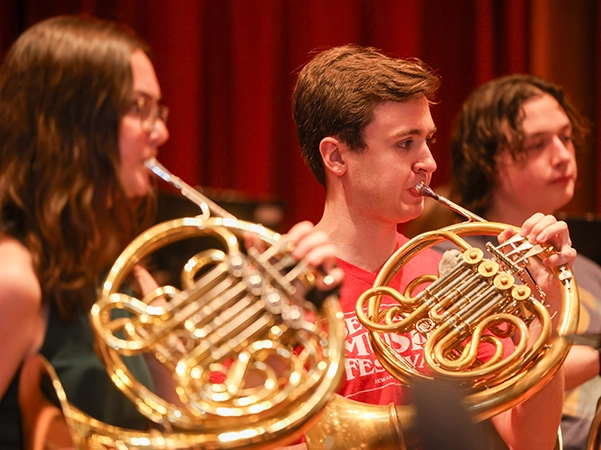 A group of students playing french horns.