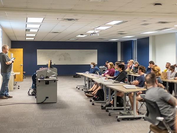 A professor giving a presentation to his class as the students pay close attention.