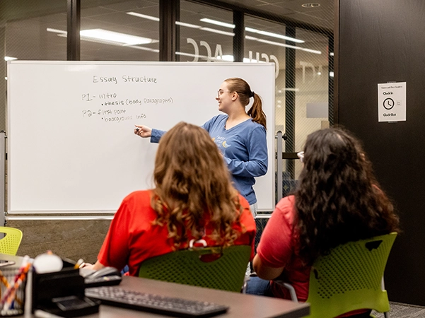 A student tutoring other students on proper essay structure.
