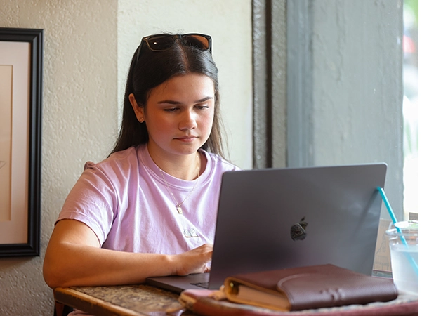 A student researching with her laptop.