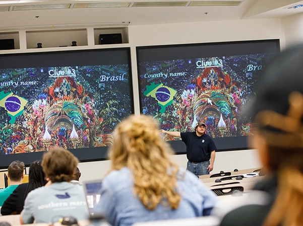 A professor giving a lecture to his students in a large study hall.
