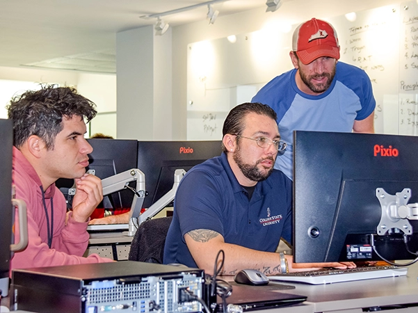 Three students researching together at a computer