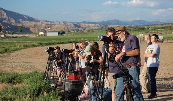 Several students and profesors looking through telescopes