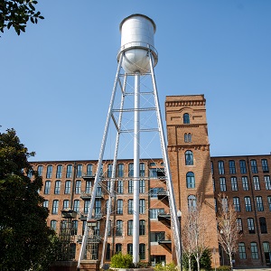a water tower in front of a large brick building