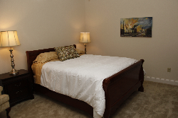 a bedroom with a large bed with white sheets
