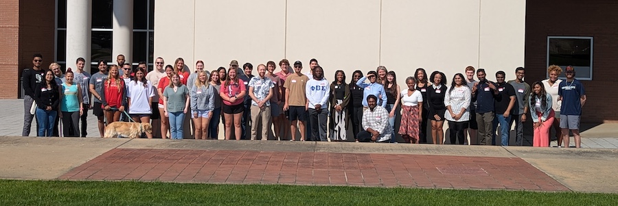 Graduate Students Group Photo sitting on lawn